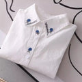 Women's white shirt made of pure cotton, with a fold-down collar, long sleeves, and embroidery.