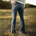 Women's vintage bell-bottom jeans with embroidered pockets.