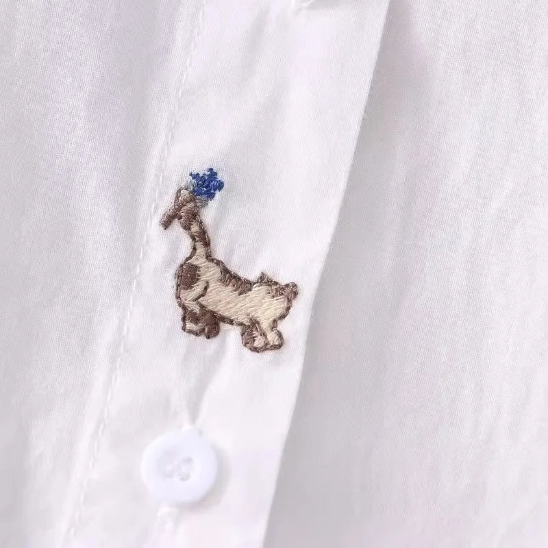 Women's white shirt made of pure cotton, with a fold-down collar, long sleeves, and embroidery.