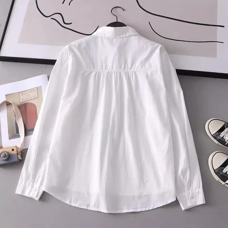 Women's white shirt made of pure cotton, with a fold-down collar, long sleeves, and embroidery.
