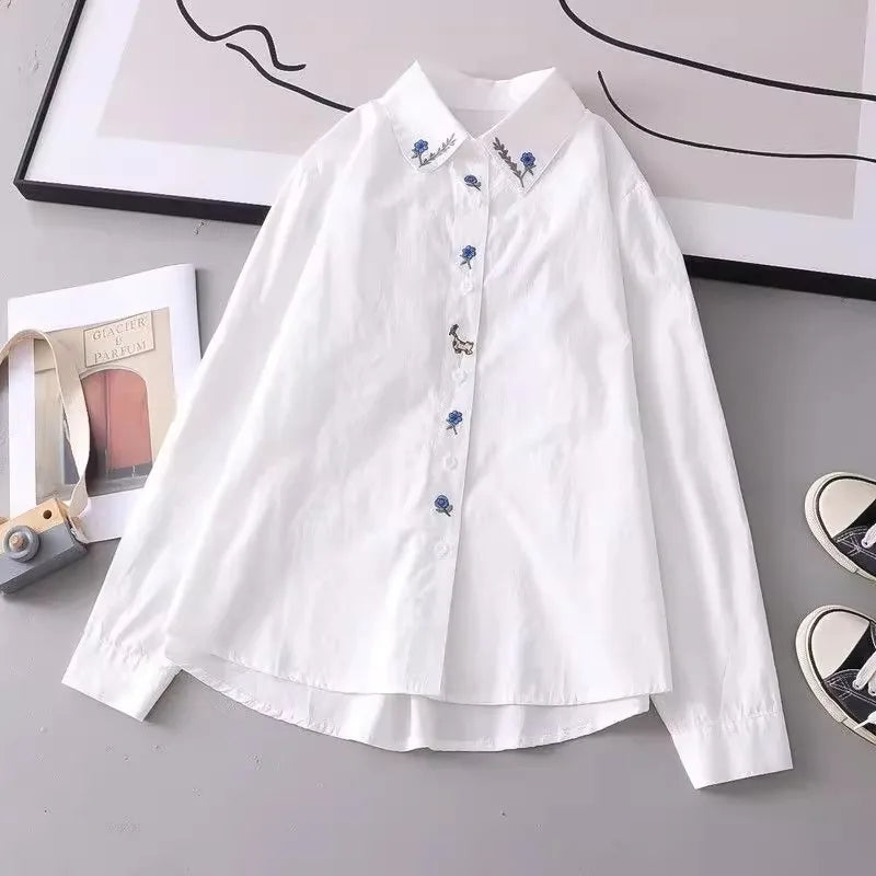 Women's white shirt made of pure cotton, with a fold-down collar, long sleeves, and embroidery.